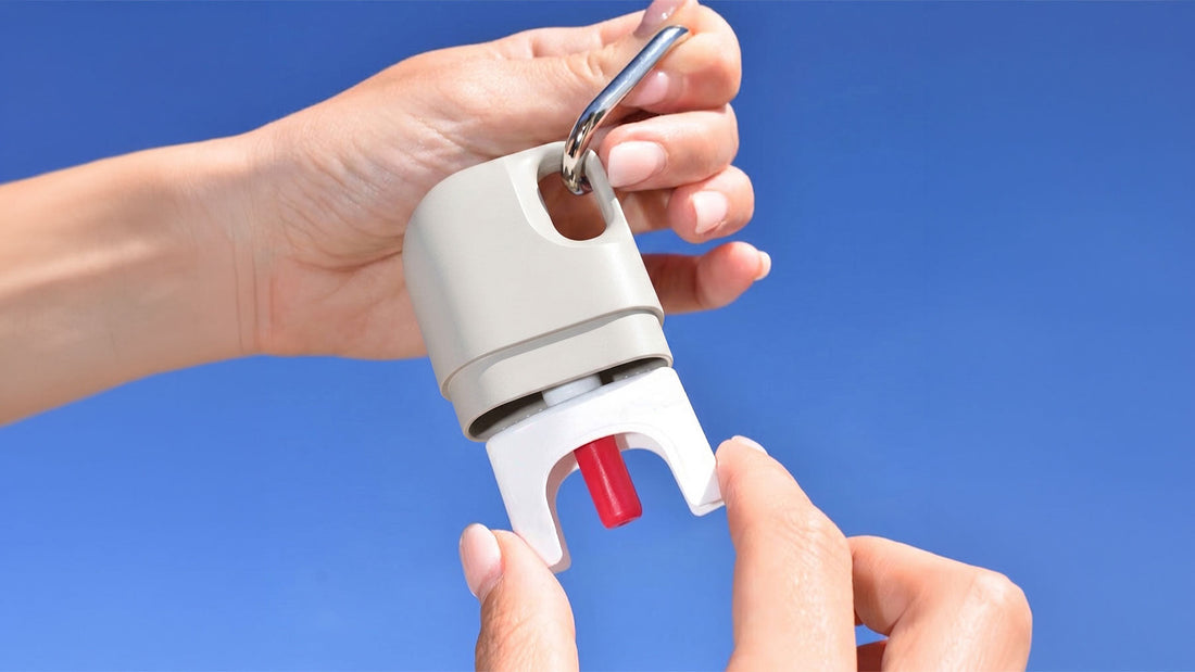 Hands opening a Nove naloxone nasal spray case with a steel carabiner